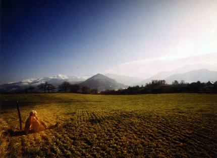Photo du Dr Lefebure à l'emplacement d'où Bernadette voyait la chaîne des Pyrénées, tout en gardant ses moutons. On remarquera la forte brillance des brumes au-dessus des montagnes.